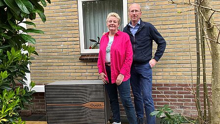 Tineke en Kees-Jan Appel poseren voor hun woning naast de warmtepomp.